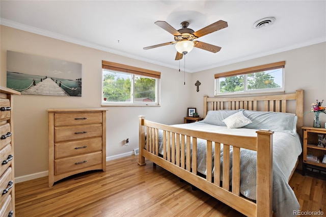 bedroom featuring baseboards, multiple windows, light wood-style flooring, crown molding, and ceiling fan