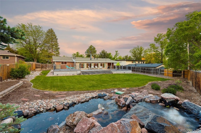 back of house at dusk with a wooden deck
