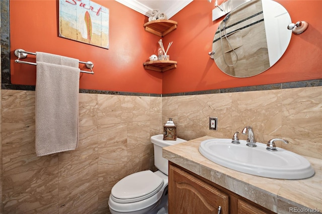 bathroom featuring crown molding, toilet, vanity, and a wainscoted wall