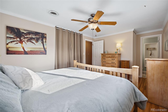 bedroom featuring ornamental molding, wood finished floors, and a ceiling fan