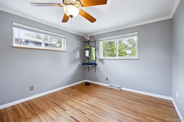unfurnished room with wood finished floors, baseboards, ornamental molding, and a ceiling fan