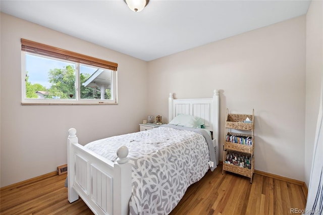 bedroom with light wood-style flooring and baseboards