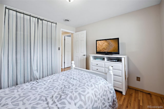bedroom with wood finished floors and baseboards