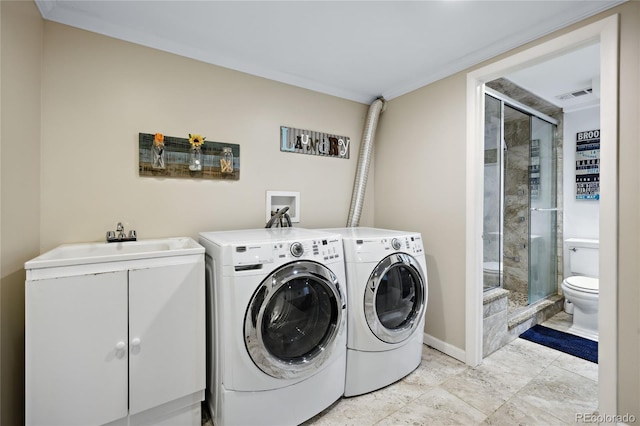washroom with washing machine and dryer, baseboards, and cabinet space