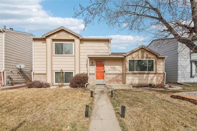 view of front of house with brick siding and a front lawn