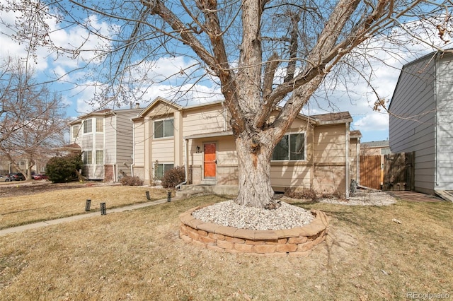 view of front of home featuring a front lawn and fence