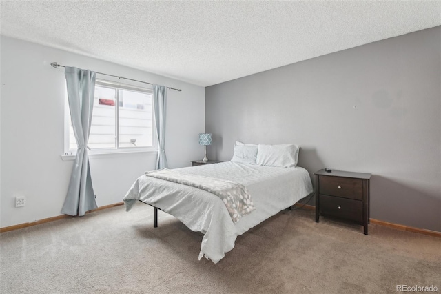 carpeted bedroom featuring baseboards and a textured ceiling