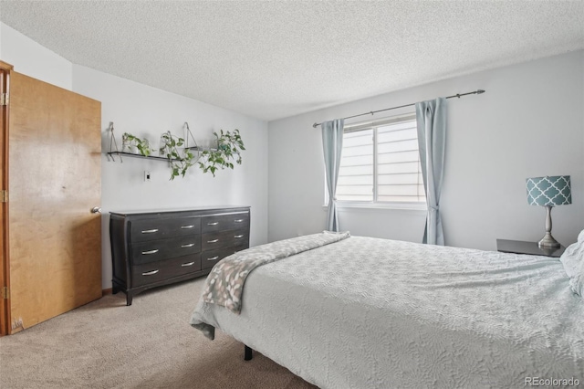 bedroom featuring light colored carpet and a textured ceiling