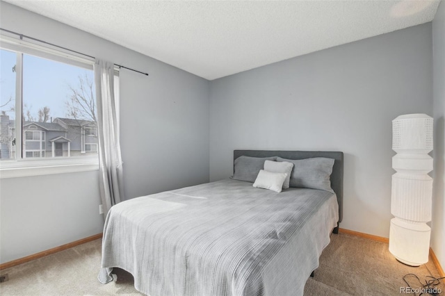 bedroom with carpet, a textured ceiling, and baseboards