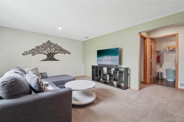 carpeted living area with baseboards, visible vents, and a textured ceiling