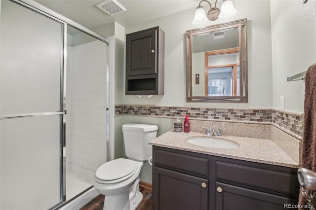 full bathroom featuring toilet, vanity, visible vents, decorative backsplash, and a stall shower