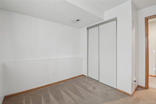 unfurnished bedroom featuring carpet floors, baseboards, visible vents, and a closet