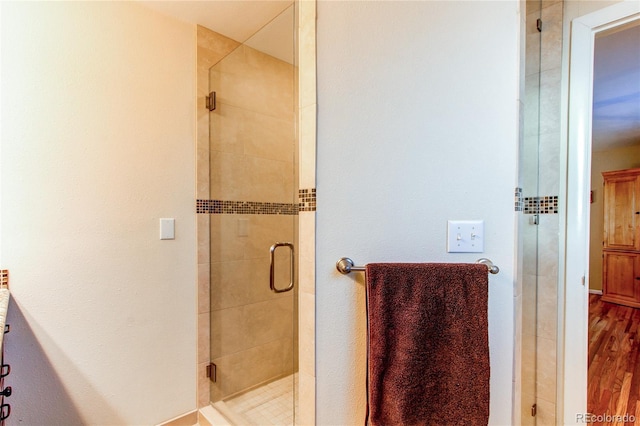 bathroom featuring vanity, an enclosed shower, and wood-type flooring