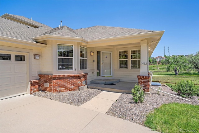 7912 S Buchanan Way, Aurora, CO 80016 - view of front facade with a shingled roof, brick siding, and covered porch
