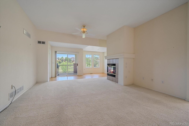7912 S Buchanan Way, Aurora, CO 80016 - unfurnished living room featuring light carpet, a tile fireplace, and ceiling fan