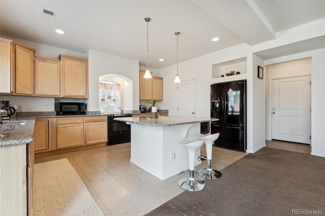 19047 Randolph Pl, Denver, CO 80249 - kitchen with a center island, light tile patterned floors, visible vents, a kitchen breakfast bar, and black appliances