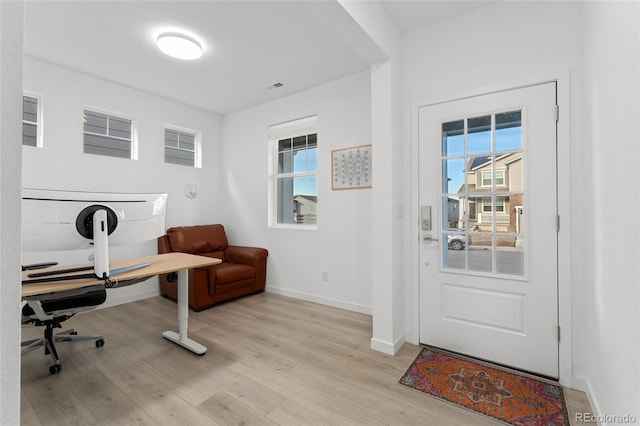 office area featuring light wood-style floors, visible vents, and baseboards