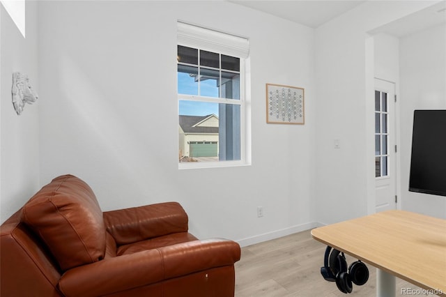 living area featuring light wood finished floors and baseboards