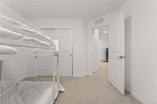 bedroom with light carpet, visible vents, and baseboards