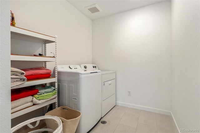 laundry area with laundry area, washing machine and dryer, visible vents, and baseboards