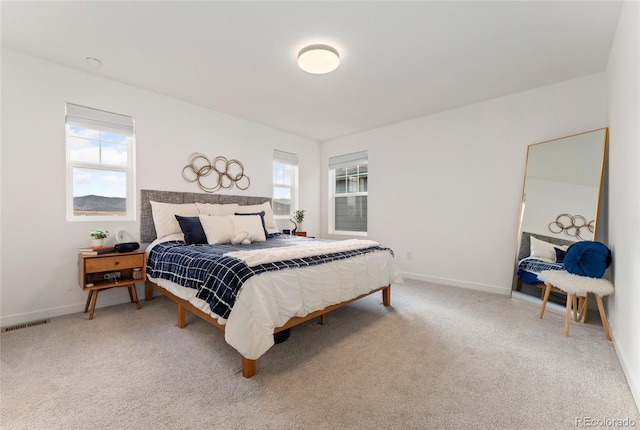 carpeted bedroom with visible vents and baseboards