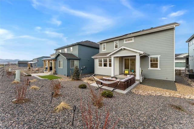 rear view of property featuring a patio, solar panels, and fence