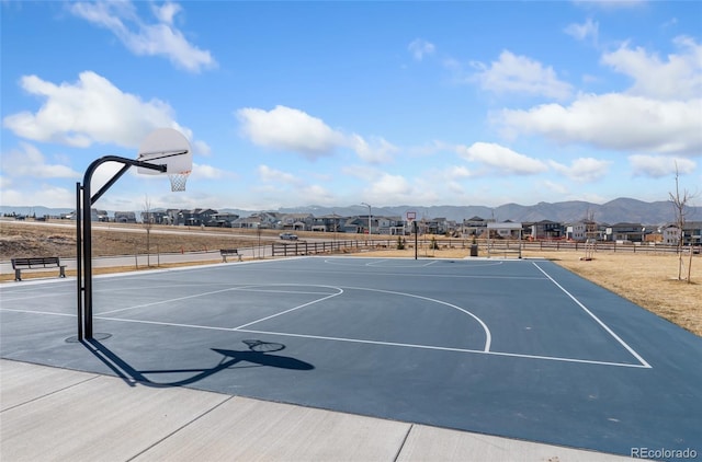 view of basketball court featuring a mountain view, community basketball court, and fence