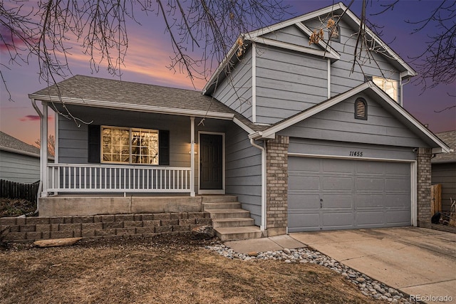 tri-level home featuring a garage, driveway, a porch, and roof with shingles