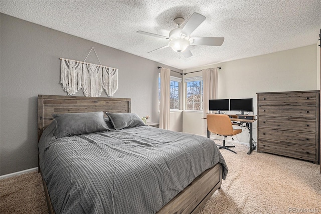 bedroom with a textured ceiling, carpet flooring, a ceiling fan, and baseboards