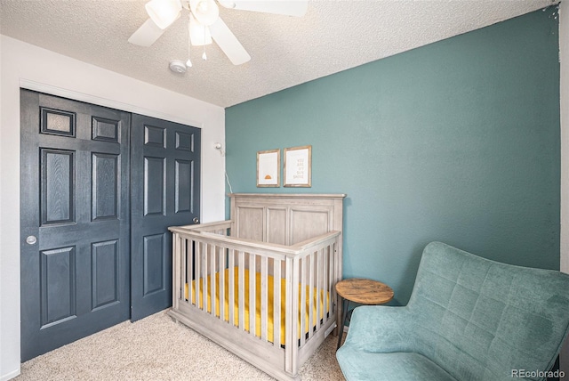 bedroom featuring a textured ceiling, carpet, and a ceiling fan