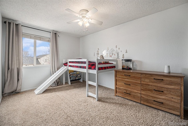 bedroom with a ceiling fan, carpet flooring, a textured ceiling, and baseboards