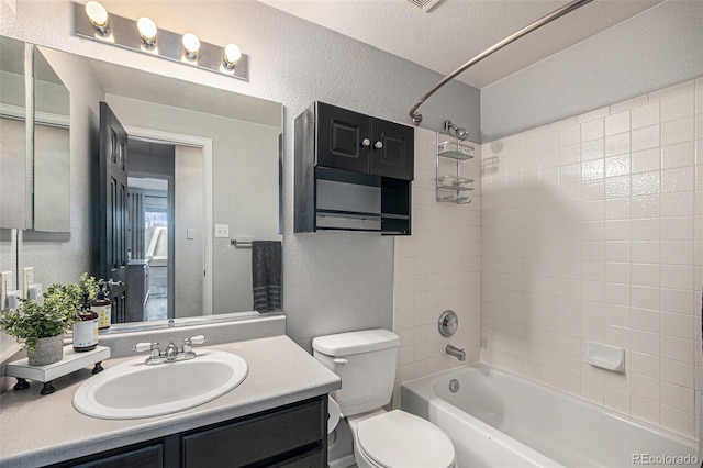 full bath featuring shower / bathtub combination, a textured wall, vanity, and toilet