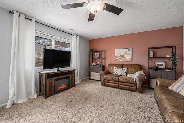 carpeted living room with a ceiling fan, baseboards, visible vents, and a textured ceiling