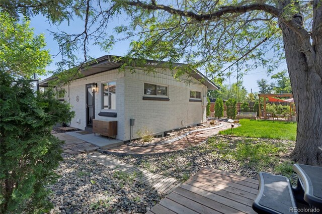 9400 Ridge Rd, Arvada, CO 80002 - view of side of home featuring brick siding and a deck