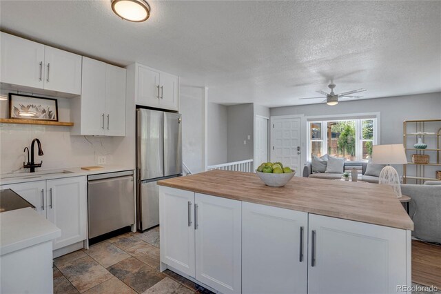 9400 Ridge Rd, Arvada, CO 80002 - kitchen featuring stainless steel appliances, open floor plan, butcher block counters, ceiling fan, and open shelves
