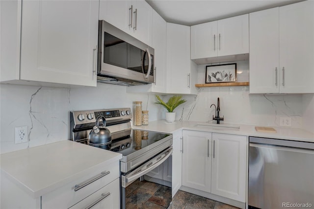 9400 Ridge Rd, Arvada, CO 80002 - kitchen with stainless steel appliances, light countertops, white cabinetry, and backsplash
