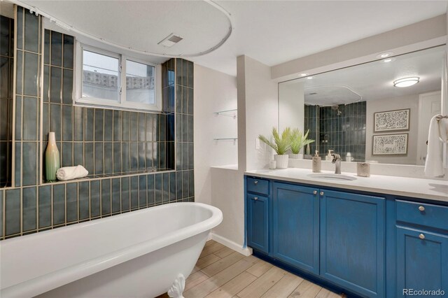 9400 Ridge Rd, Arvada, CO 80002 - bathroom with a soaking tub, vanity, and wood finished floors