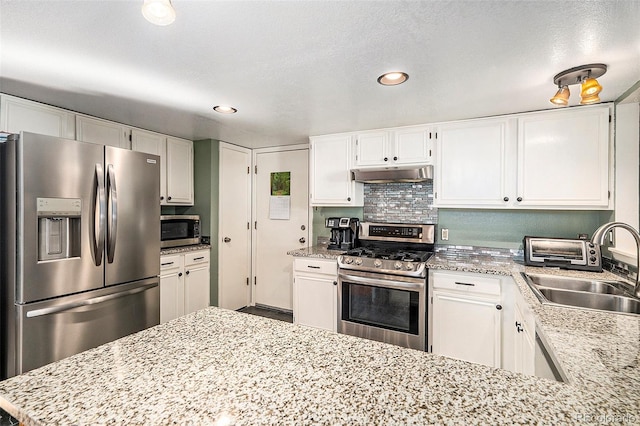 7582 Jared Way, Littleton, CO 80125 - kitchen featuring stainless steel appliances, under cabinet range hood, white cabinetry, recessed lighting, and light stone counters