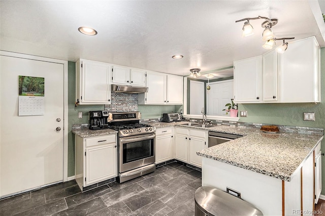 7582 Jared Way, Littleton, CO 80125 - kitchen with appliances with stainless steel finishes, under cabinet range hood, a peninsula, white cabinetry, and light stone counters
