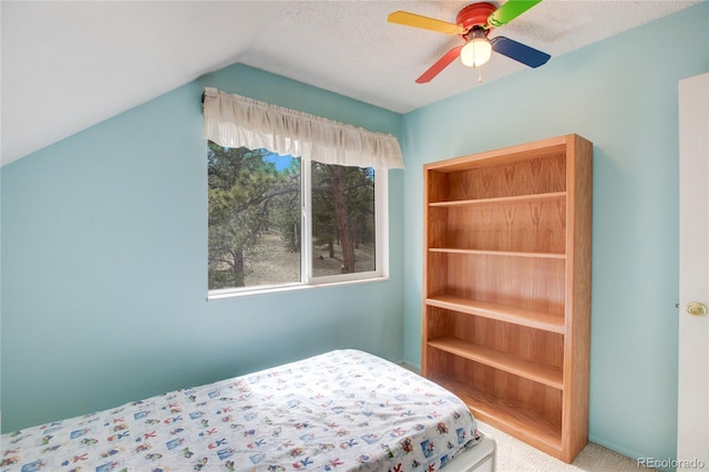 unfurnished bedroom featuring carpet, a textured ceiling, vaulted ceiling, and ceiling fan