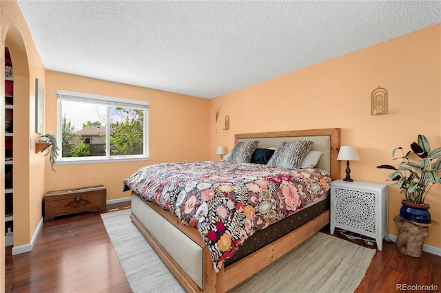 9376 W Wagon Trail Cir, Littleton, CO 80123 - bedroom featuring wood finished floors, a textured ceiling, and baseboards