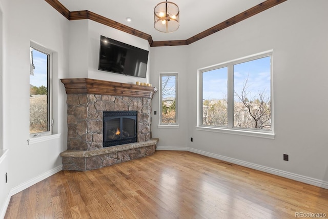 unfurnished living room featuring a stone fireplace, ornamental molding, and light hardwood / wood-style floors