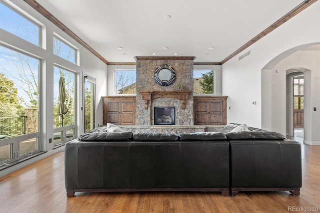 unfurnished living room featuring a fireplace, ornamental molding, and light wood-type flooring