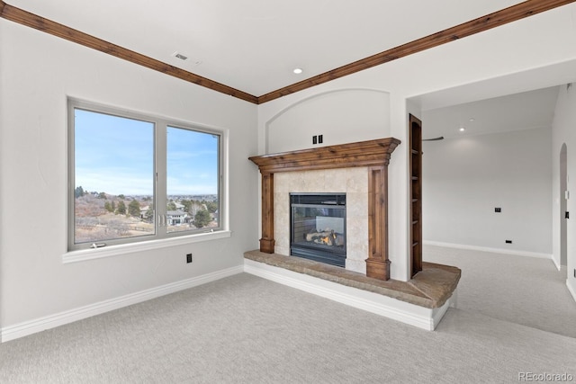 unfurnished living room with a tile fireplace, carpet, and ornamental molding