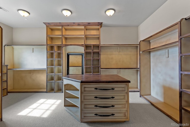 walk in closet featuring light carpet