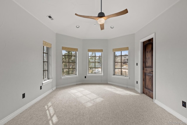 unfurnished room featuring ceiling fan, light colored carpet, and a healthy amount of sunlight