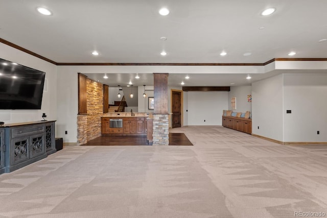 unfurnished living room with sink, crown molding, and light colored carpet