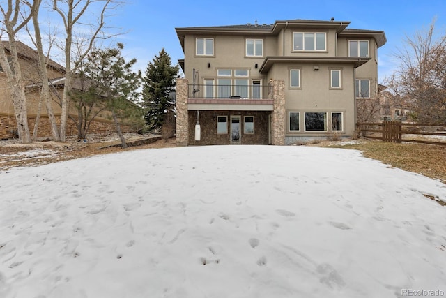 snow covered property featuring a balcony