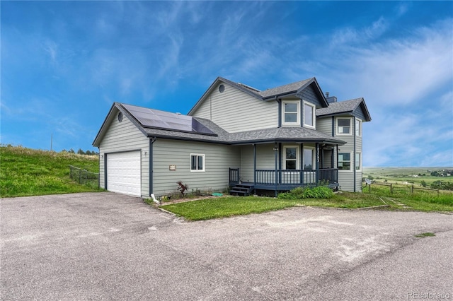 43793 Buckskin Rd, Parker, CO 80138 - view of front facade with a porch, solar panels, asphalt driveway, a garage, and roof with shingles