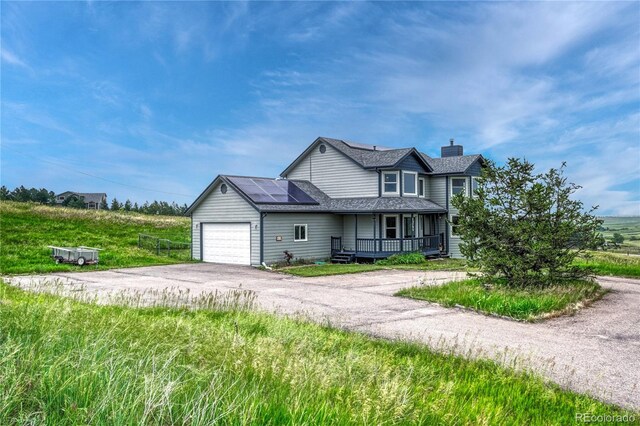 43793 Buckskin Rd, Parker, CO 80138 - traditional-style home featuring asphalt driveway, a chimney, a garage, roof mounted solar panels, and a porch